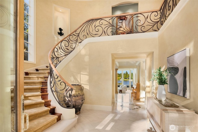 3602 Evergreen Point Rd, Medina, WA 98039 - stairway with baseboards, a towering ceiling, and a water view