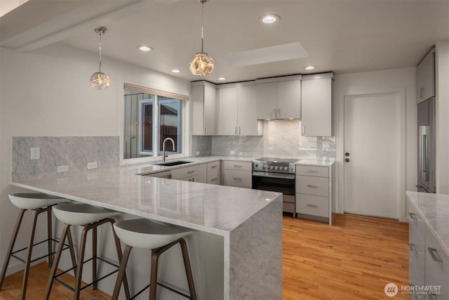 10837 Bill Point Blf NE, Bainbridge Island, WA 98110 - kitchen with decorative backsplash, a peninsula, light stone countertops, stainless steel electric range, and a sink