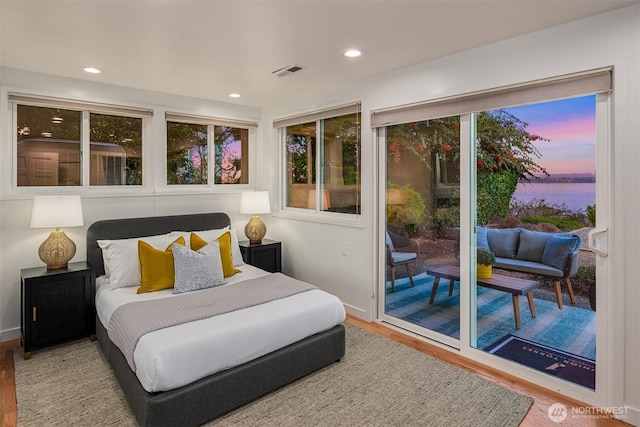 10837 Bill Point Blf NE, Bainbridge Island, WA 98110 - bedroom with visible vents, wood finished floors, access to outside, recessed lighting, and a water view