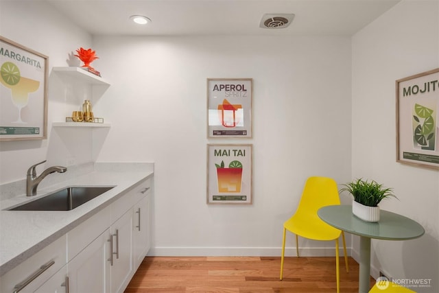 10837 Bill Point Blf NE, Bainbridge Island, WA 98110 - kitchen with open shelves, a sink, light countertops, white cabinets, and light wood finished floors