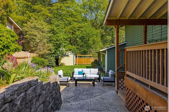 view of patio featuring an outdoor hangout area, a storage unit, an outdoor structure, and fence