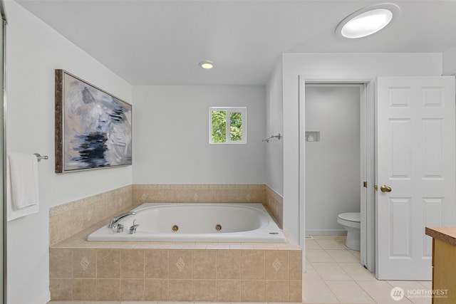 bathroom featuring tile patterned floors, a whirlpool tub, vanity, and toilet