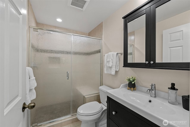 full bath with vanity, a shower stall, toilet, and visible vents