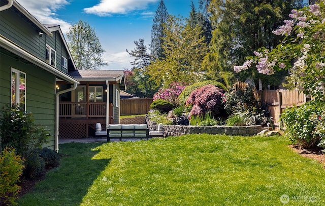 view of yard featuring fence, a wooden deck, and outdoor lounge area