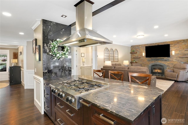 26217 137th Street Ct E, Buckley, WA 98321 - kitchen with island exhaust hood, a large fireplace, dark wood finished floors, and stainless steel gas stovetop