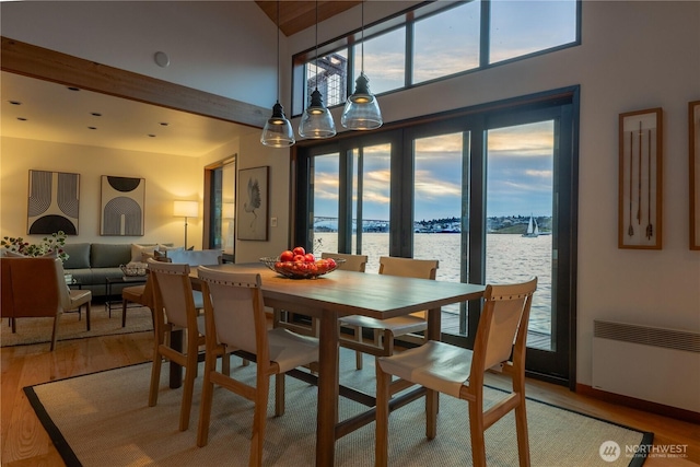 2235 Fairview Ave E Unit 12, Seattle, WA 98102 - dining area with radiator heating unit, a water view, wood finished floors, and healthy amount of natural light