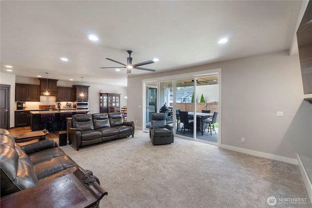 living area featuring recessed lighting, light carpet, baseboards, and a ceiling fan