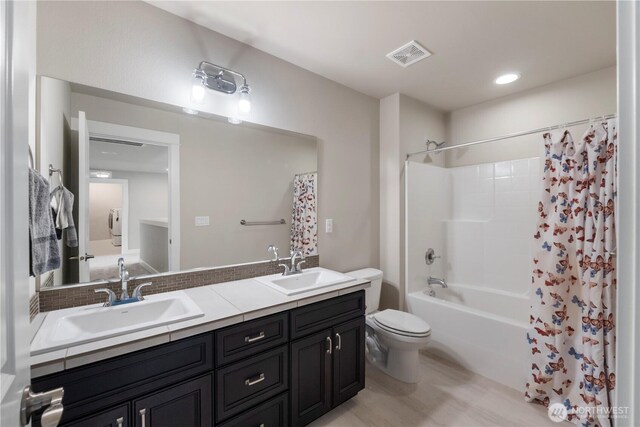 full bathroom with toilet, double vanity, and shower / bath combo