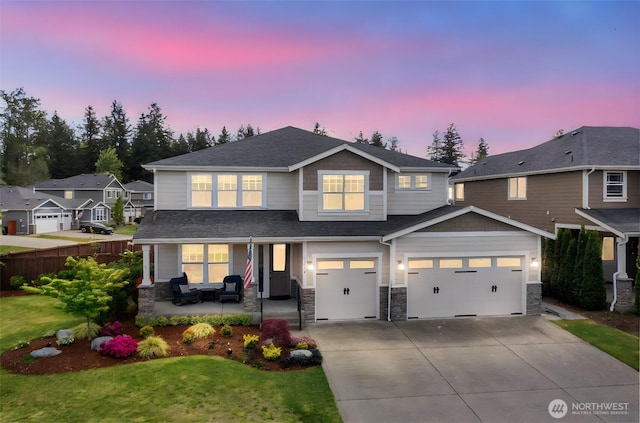 craftsman house featuring stone siding, concrete driveway, and roof with shingles