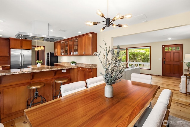 dining space featuring light wood-type flooring, recessed lighting, and a chandelier