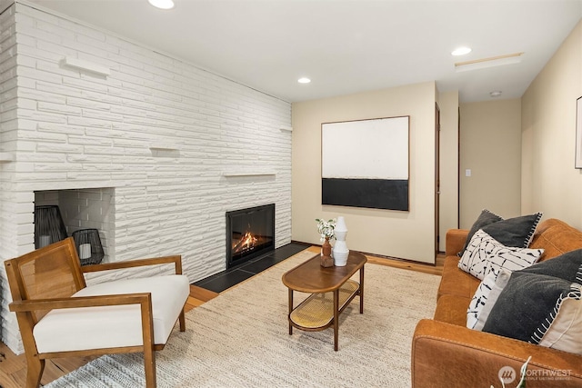 living room with recessed lighting, wood finished floors, and a fireplace