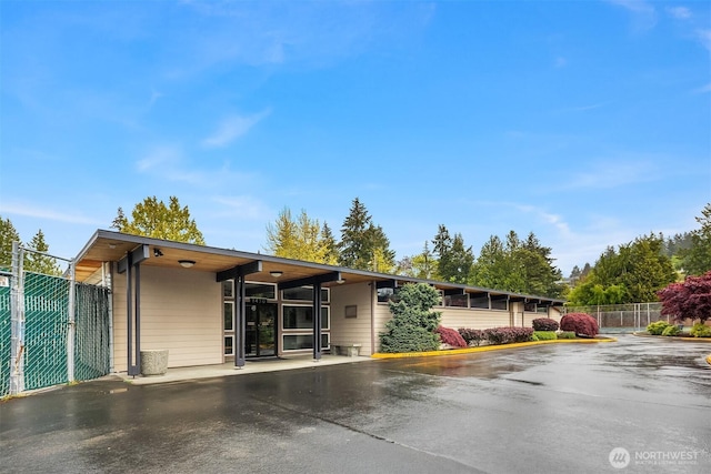 view of front of house featuring fence and uncovered parking