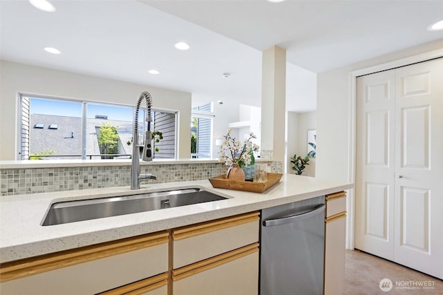kitchen featuring a healthy amount of sunlight, a sink, tasteful backsplash, and dishwasher