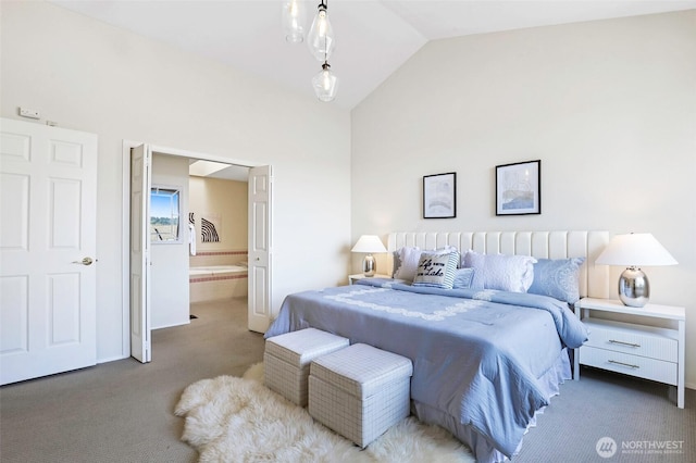 bedroom featuring lofted ceiling, carpet, and ensuite bath