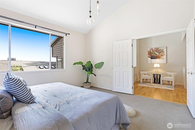 bedroom with carpet floors, baseboards, and vaulted ceiling