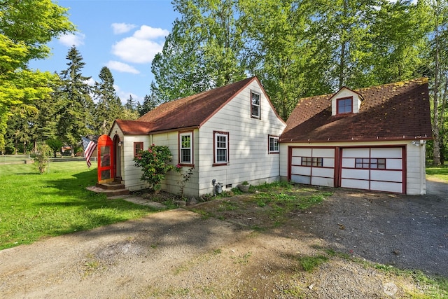 view of side of home with a shingled roof, a yard, an outbuilding, and a detached garage