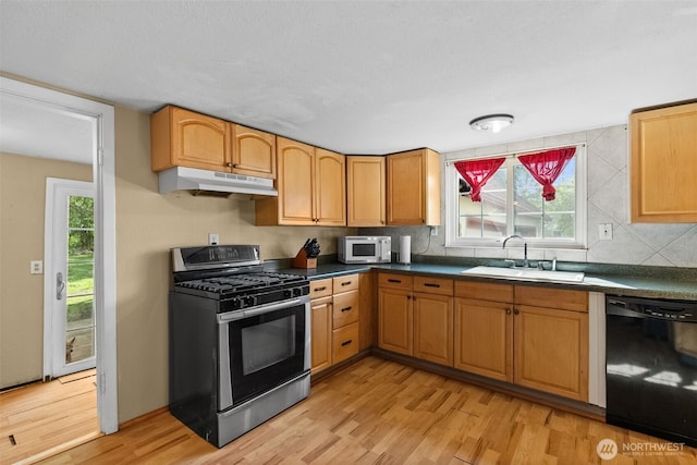kitchen with a sink, dishwasher, stainless steel range with gas stovetop, white microwave, and under cabinet range hood