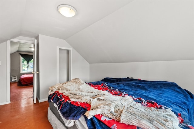bedroom with wood finished floors and vaulted ceiling