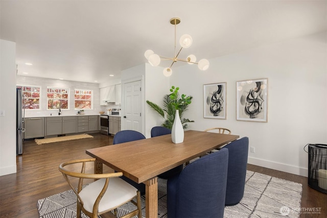 dining room with recessed lighting, baseboards, dark wood-style flooring, and a notable chandelier