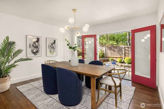 dining area featuring baseboards, wood finished floors, and a chandelier