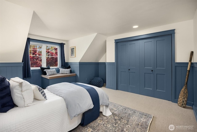 bedroom with a closet, carpet floors, and wainscoting