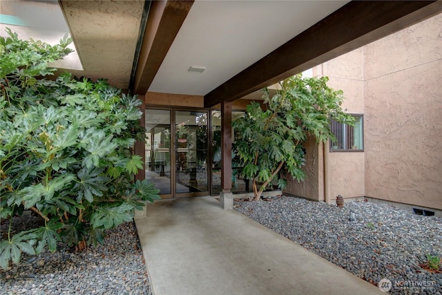 doorway to property featuring stucco siding and french doors