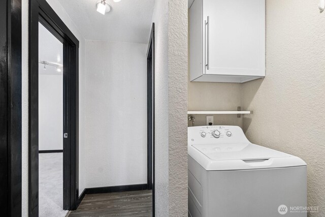 clothes washing area with washer / dryer, a textured wall, dark wood-style flooring, and cabinet space