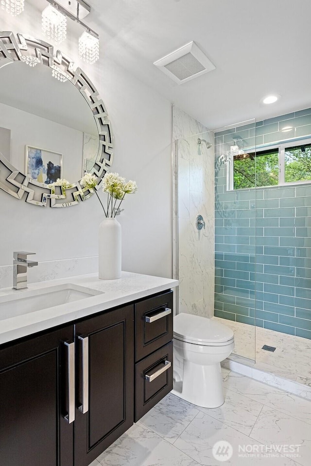 bathroom with vanity, a shower stall, toilet, and marble finish floor