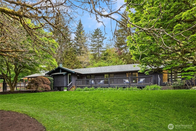 back of property with a yard and a deck