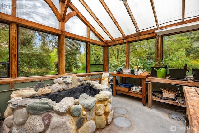 sunroom / solarium featuring concrete flooring and vaulted ceiling