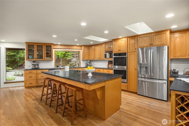 kitchen with backsplash, stainless steel appliances, and a skylight