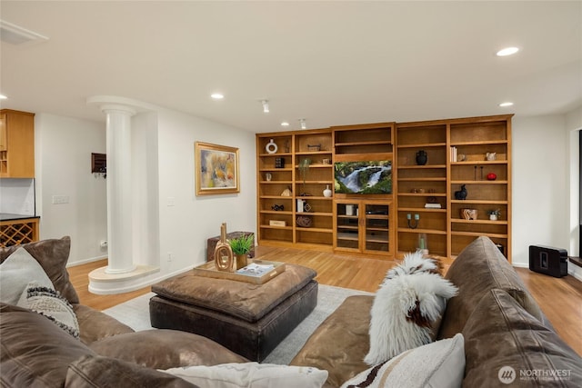 living room featuring recessed lighting, decorative columns, wood finished floors, and visible vents