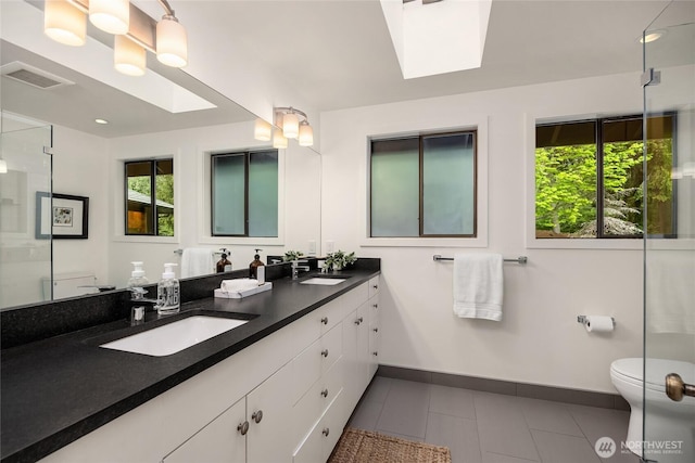 full bathroom featuring toilet, visible vents, a wealth of natural light, and a sink