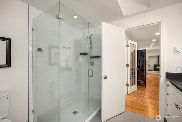 full bathroom featuring recessed lighting, toilet, tile patterned floors, and a stall shower
