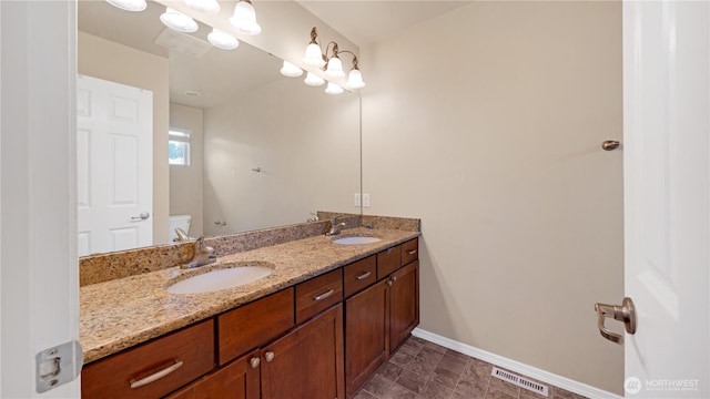 bathroom with a sink, baseboards, toilet, and visible vents