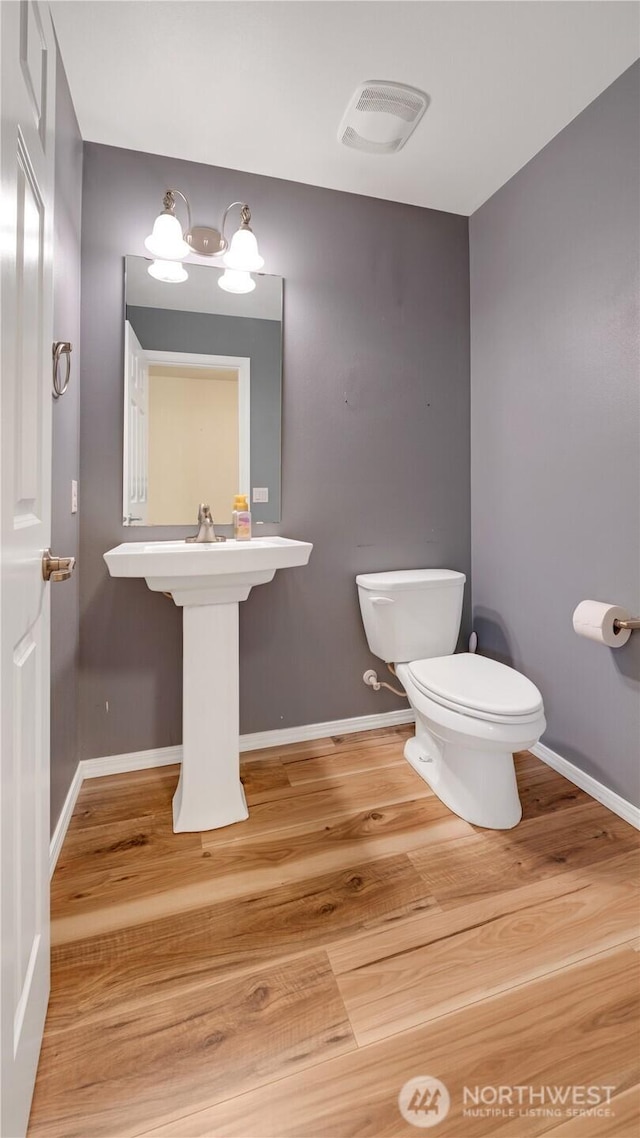 bathroom featuring baseboards, toilet, and wood finished floors