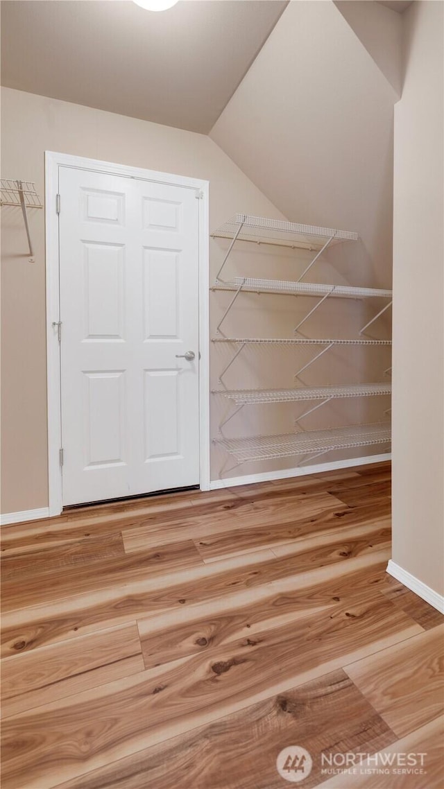 bonus room with baseboards, wood finished floors, and lofted ceiling