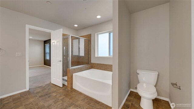 bathroom featuring baseboards, a garden tub, a stall shower, and toilet