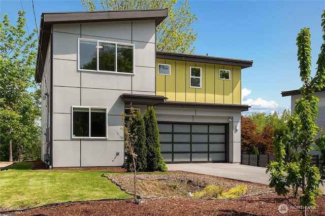 modern home featuring a garage, a front lawn, board and batten siding, and concrete driveway
