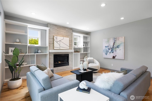 living room with recessed lighting, baseboards, wood finished floors, and a tile fireplace