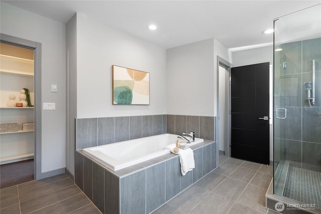 full bath featuring recessed lighting, a bath, and a stall shower