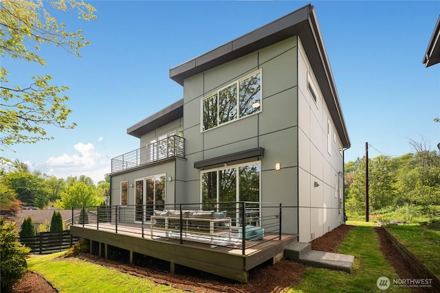rear view of property with a wooden deck and a balcony