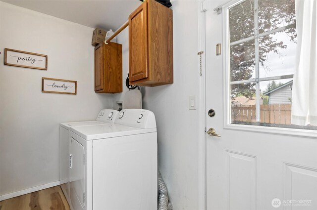 laundry area featuring separate washer and dryer and cabinet space