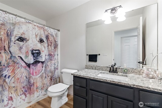 full bath with vanity, toilet, wood finished floors, and a shower with shower curtain