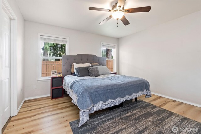 bedroom featuring baseboards, ceiling fan, and light wood finished floors