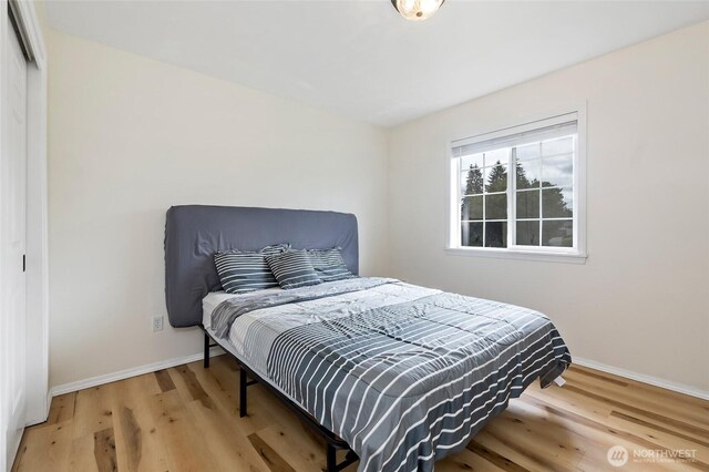 bedroom featuring baseboards, a closet, and wood finished floors