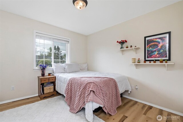 bedroom with baseboards and wood finished floors