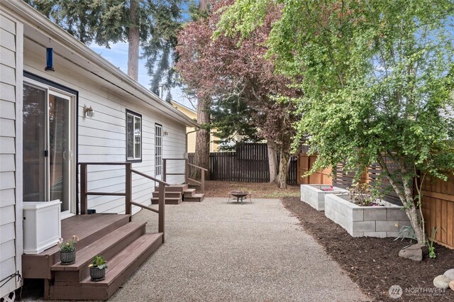 view of yard featuring fence, an outdoor fire pit, and a patio area