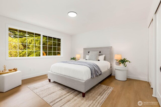 bedroom with baseboards and light wood finished floors