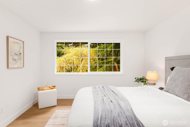 bedroom with light wood-style floors and baseboards